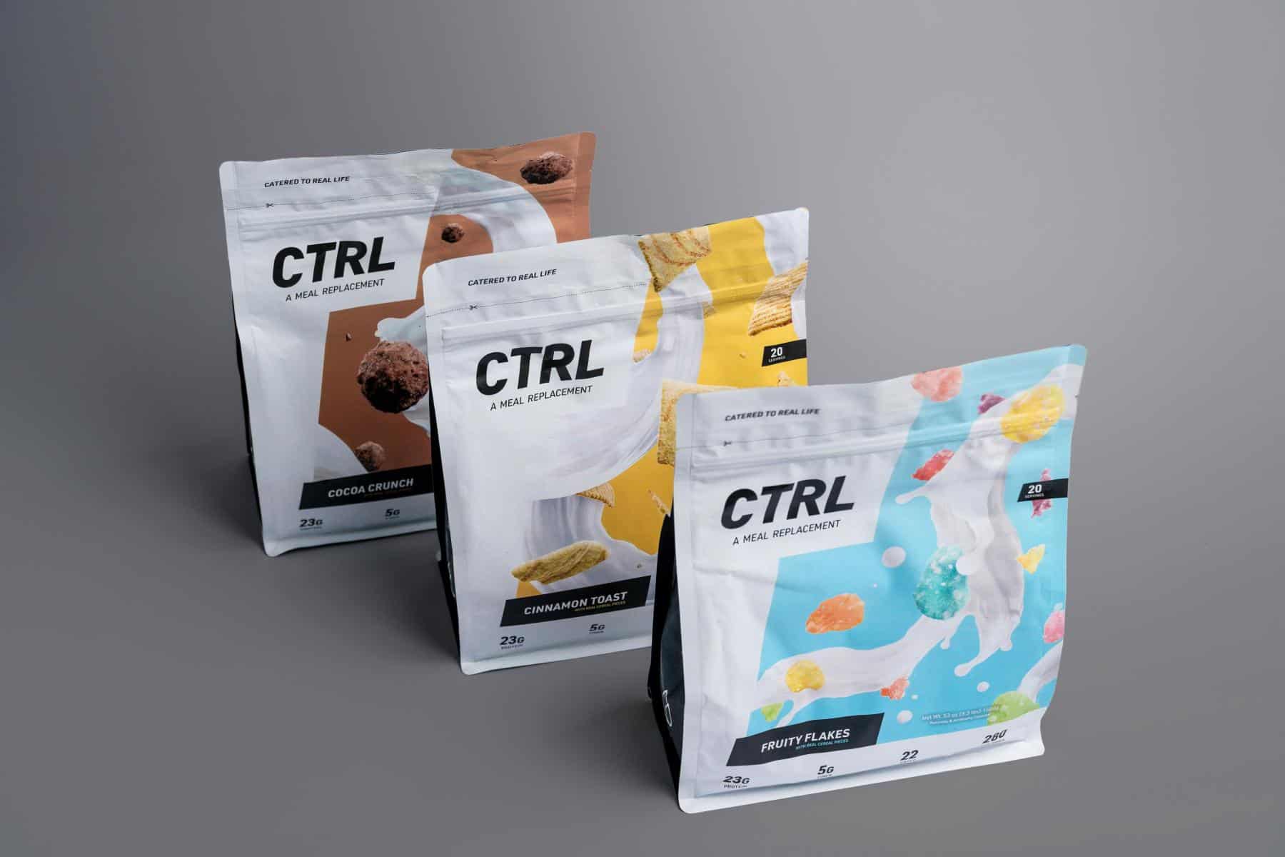 Three CTRL meal replacement bags in Cocoa Crunch, Cinnamon Toast, and Fruity Flakes flavors are arranged on a gray surface.