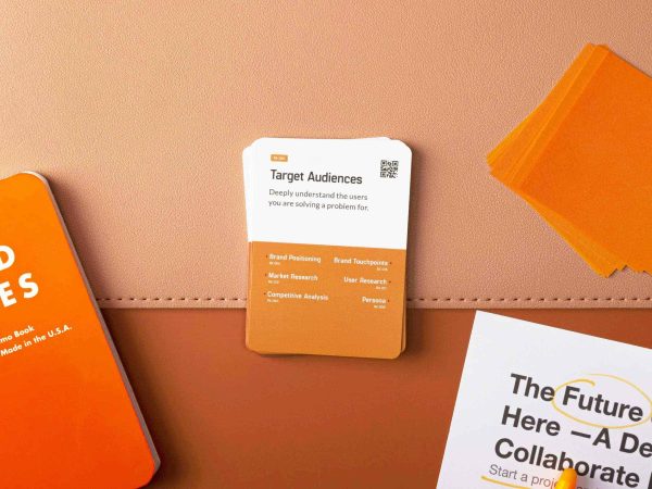 A stack of reference cards labeled “Target Audiences” on a tan surface, surrounded by other orange and white cards and papers.